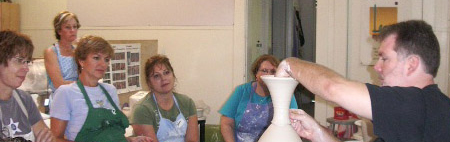 conner burns working on the final detail of a vase at a workshop